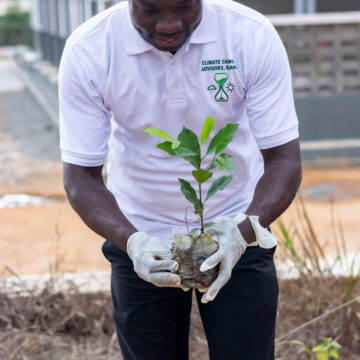 Dr. Samuel Ofori planting a tree at the Holy Child School